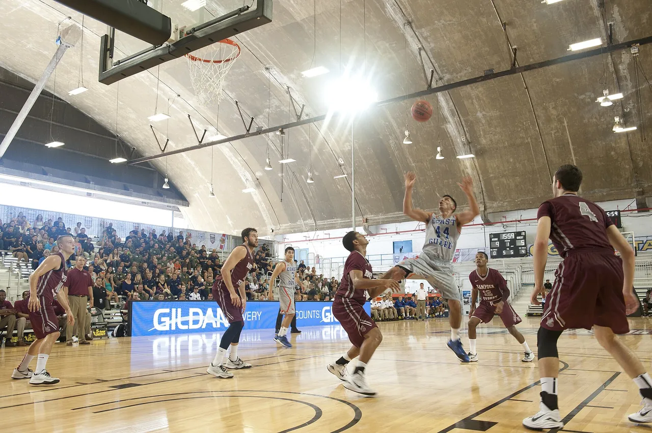 A college game in a packed arena, seen from the baseline