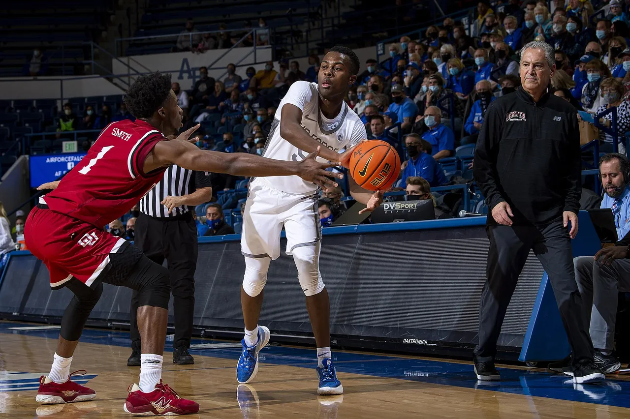 A college guard goes up for a layup in traffic