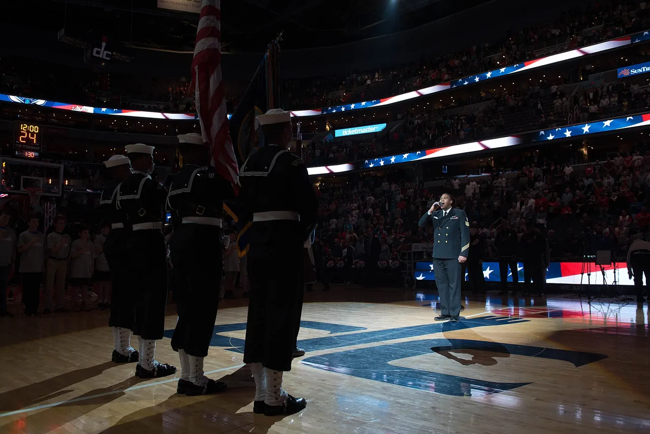 Service members stand for the anthem on an NBA court before a game