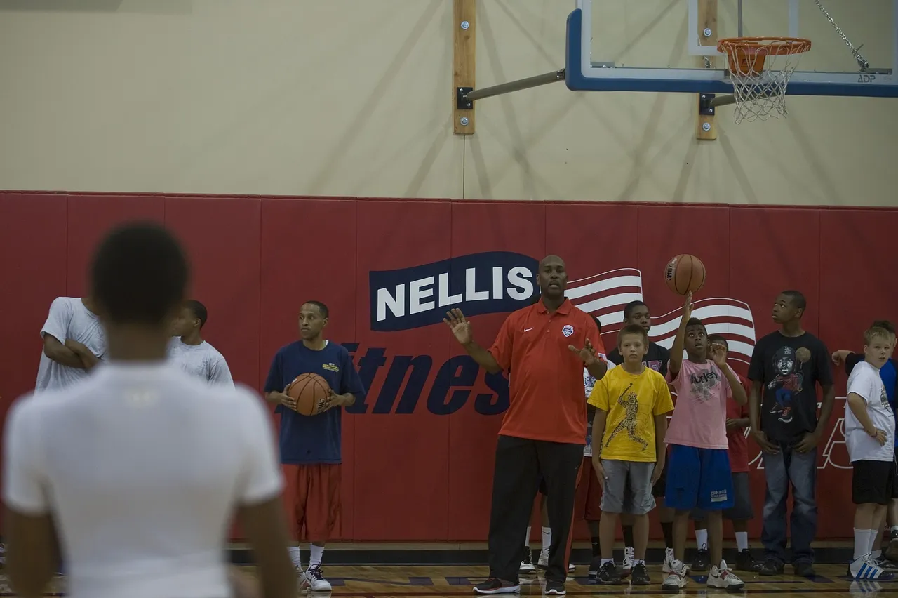 Gary Payton coaches young players at a youth basketball clinic in 2012