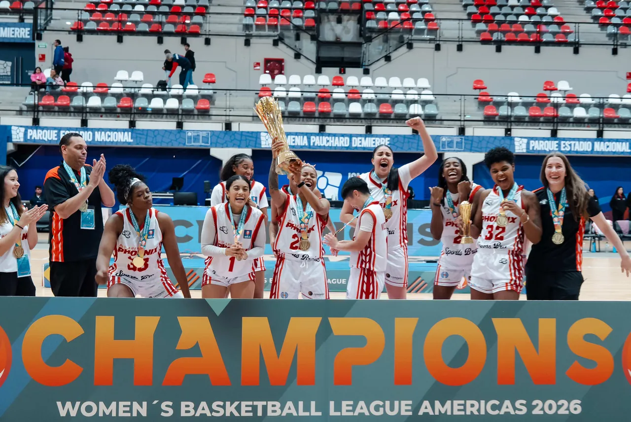 Bay Area Phoenix players and staff lift the trophy behind a Champions banner at the 2026 Women’s Basketball League Americas in Santiago, Chile