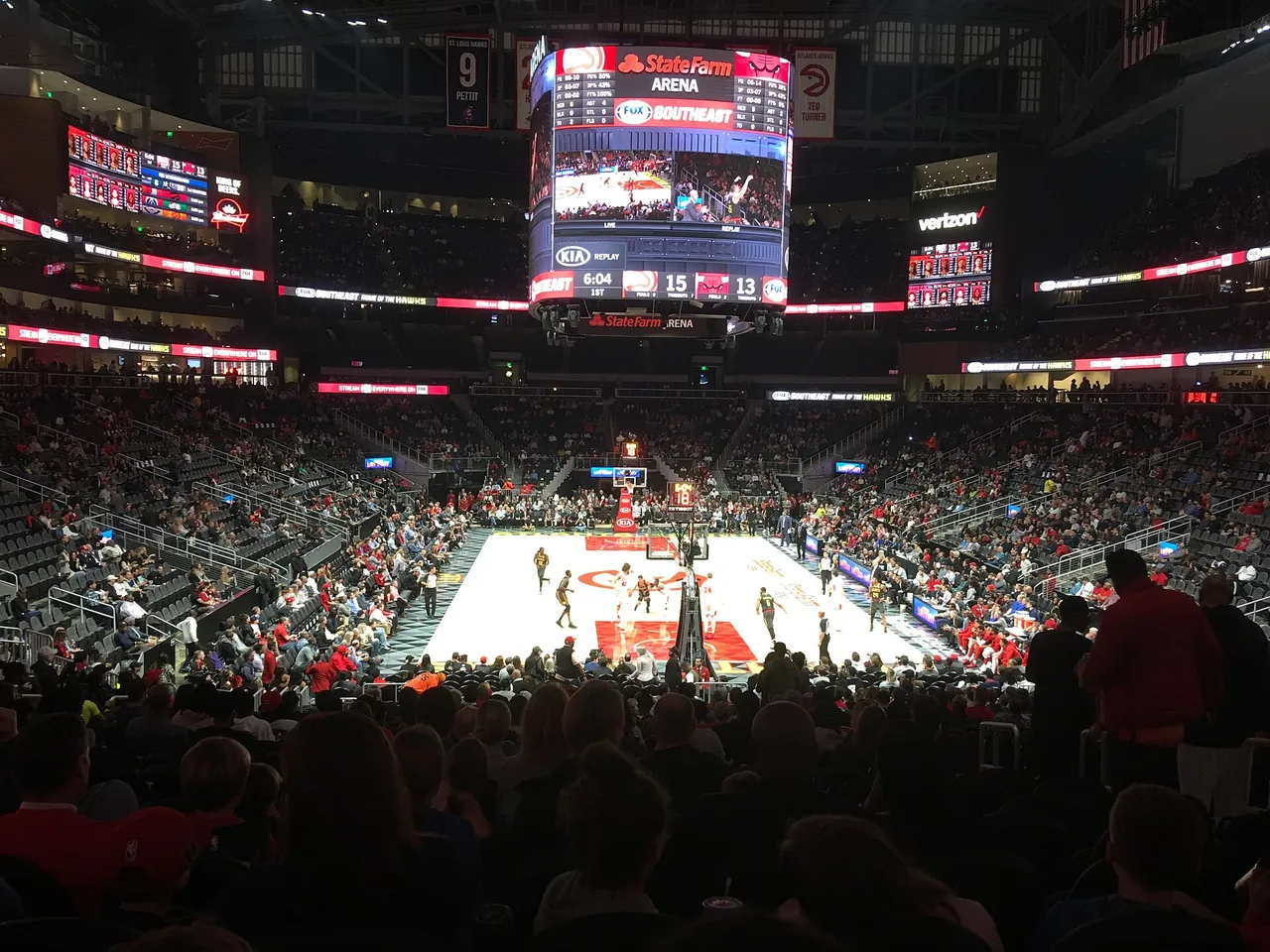 State Farm Arena in Atlanta from the lower bowl during an Atlanta Hawks game, with the center scoreboard lit