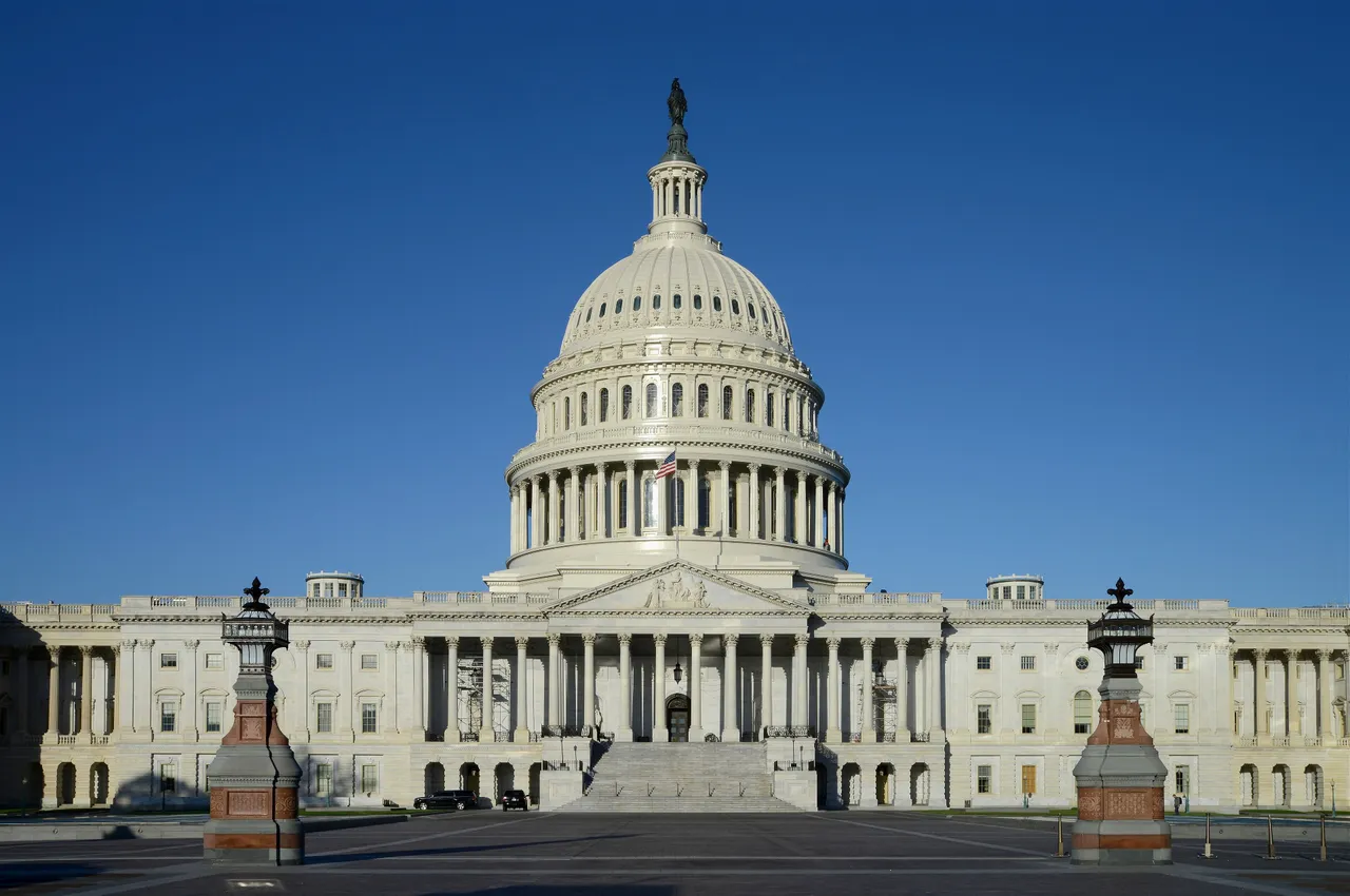The east front of the United States Capitol building under a clear blue sky.