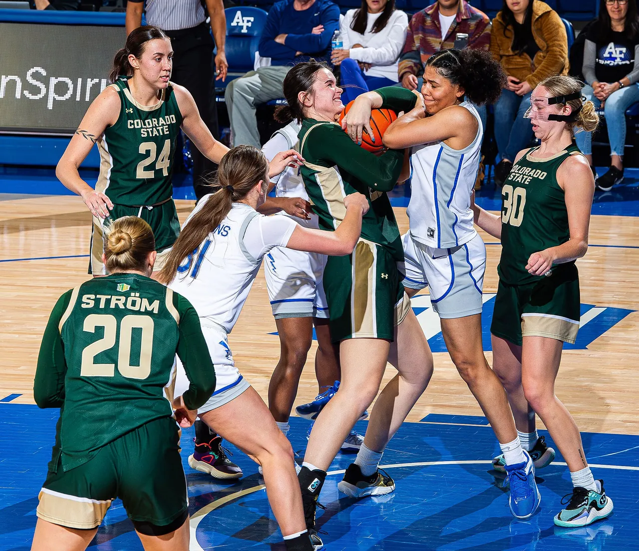 Women's college players battle for the ball during a conference game