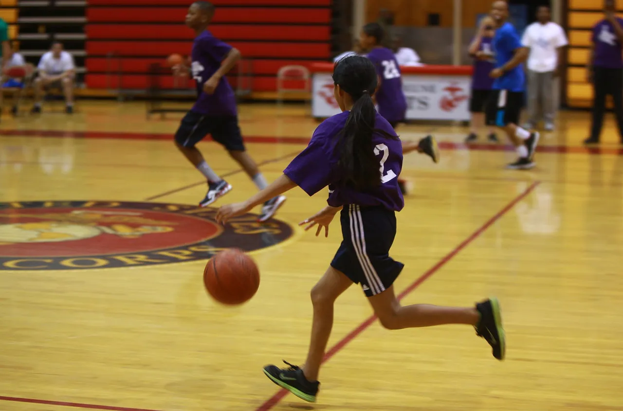 A young player drives upcourt during an organized youth game