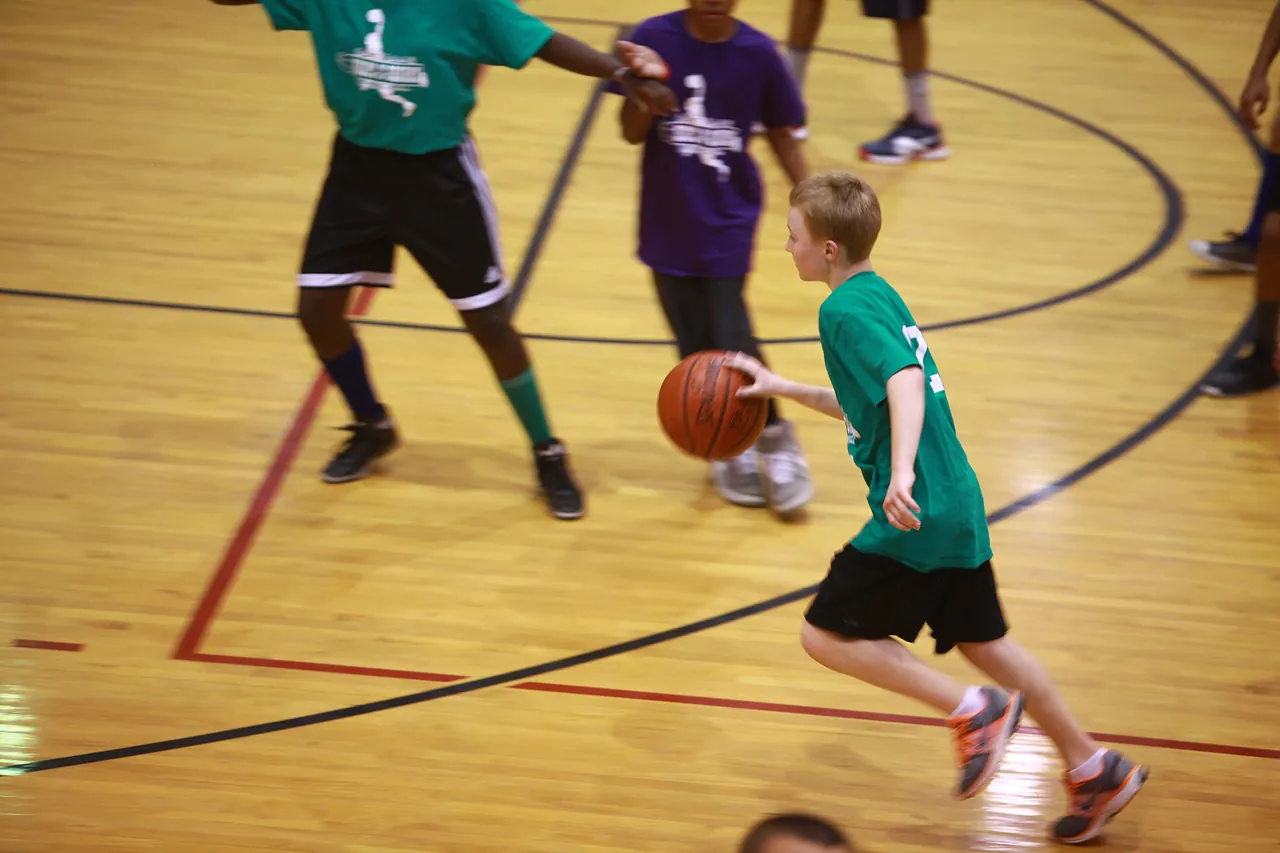 Youth players compete in a league game under a coach's eye